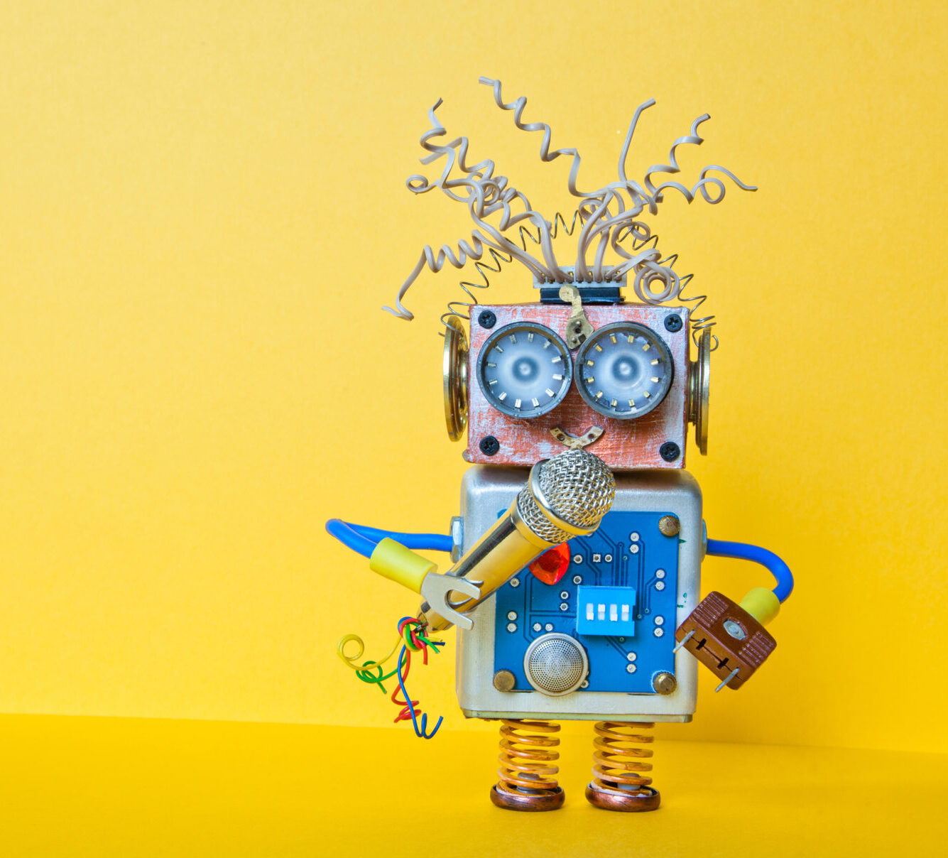 Petit robot coloré tenant un micro – symbole d'apprentissage ludique et de communication créative avec Know Futures - formations DISC